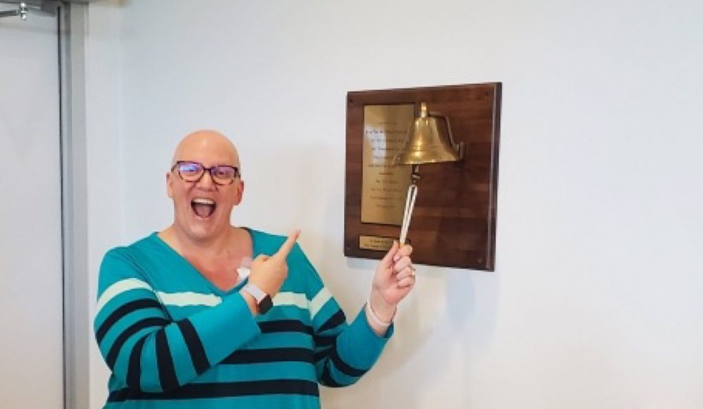 Mitzi Merkel, cancer survivor, ringing the bell at CARTI Cancer Center